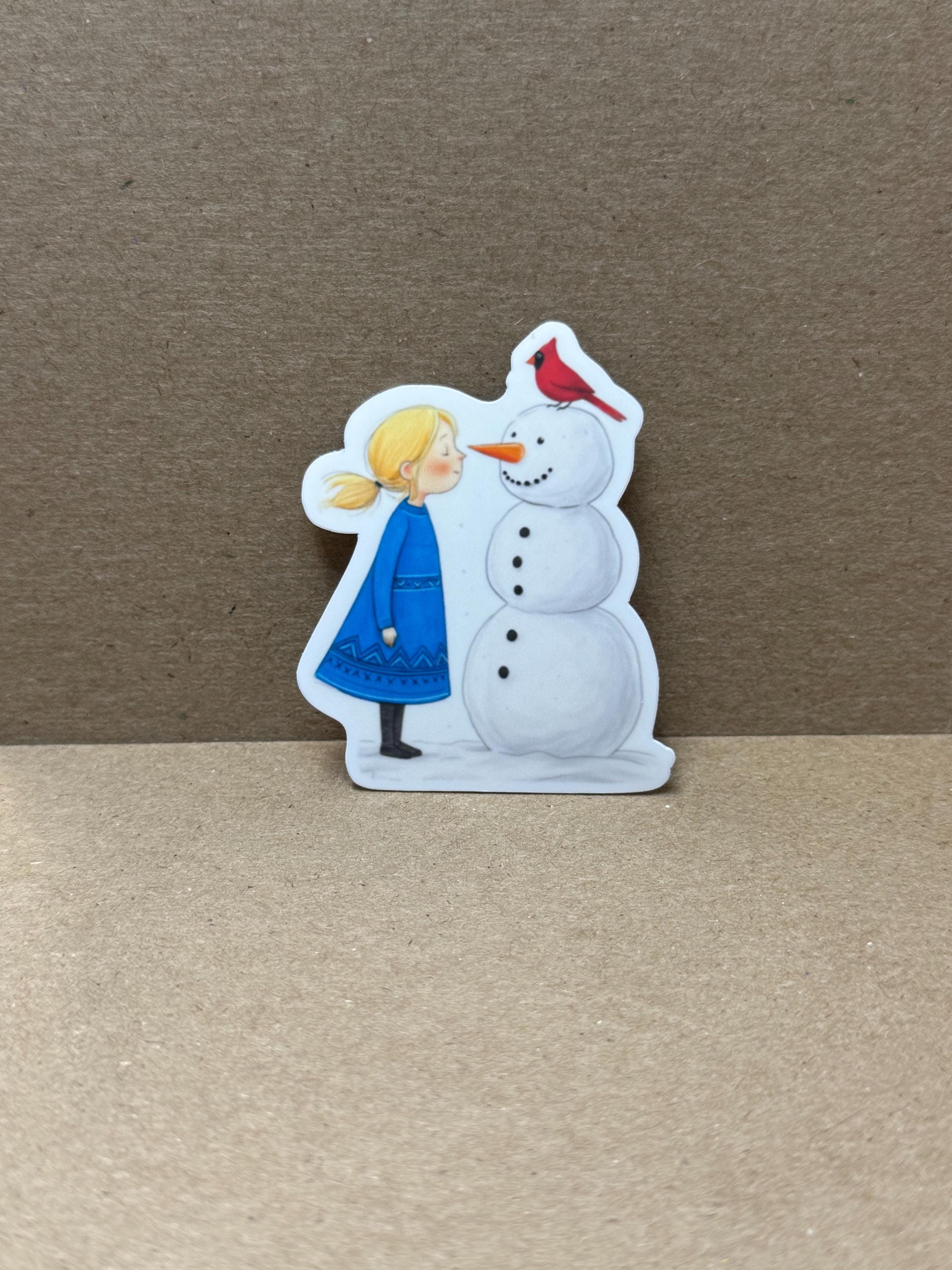 A sticker depicting a snowman with a girl, likely representing a winter scene.