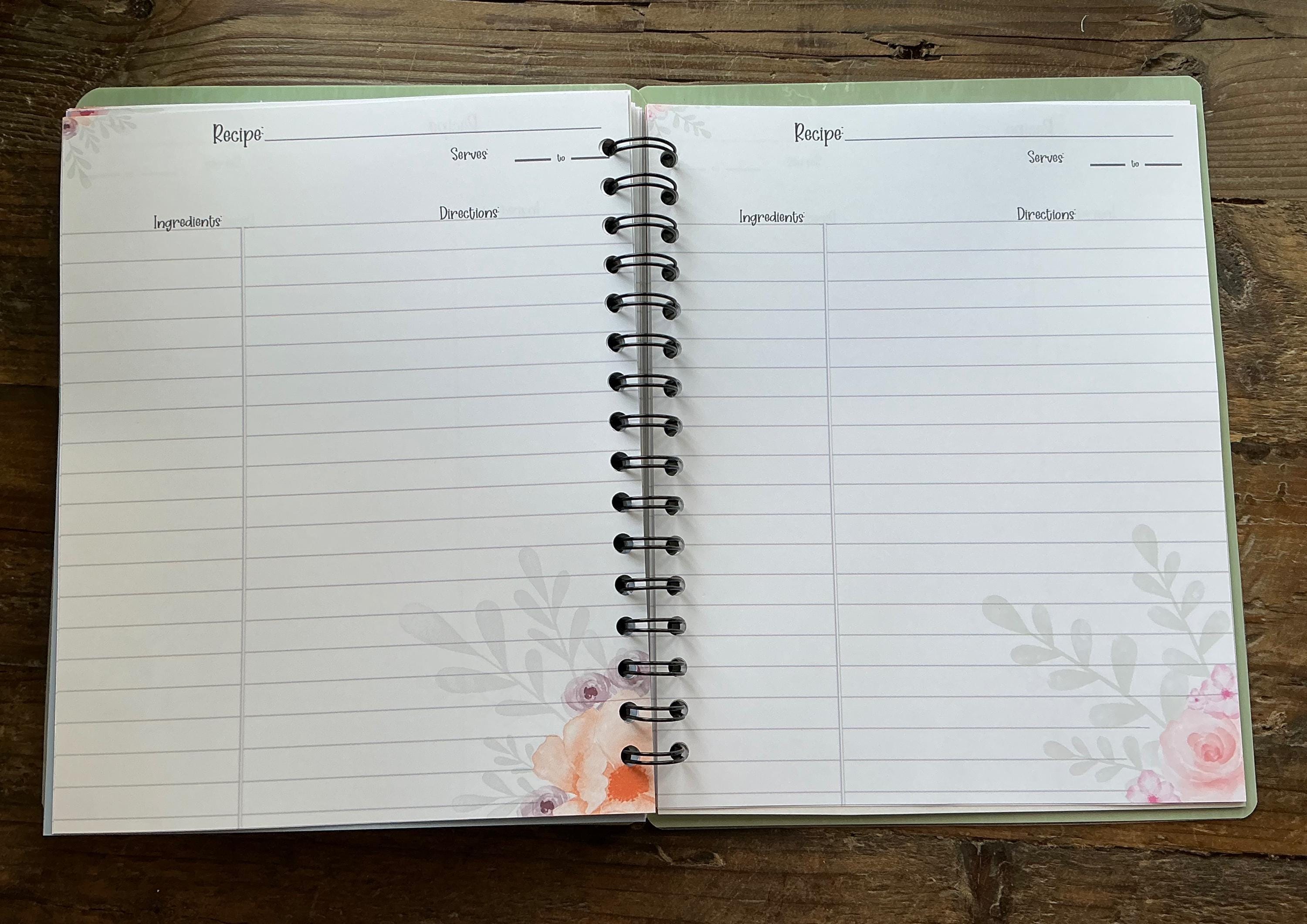 an open spiral-bound recipe book with blank pages, resting on a wooden surface.