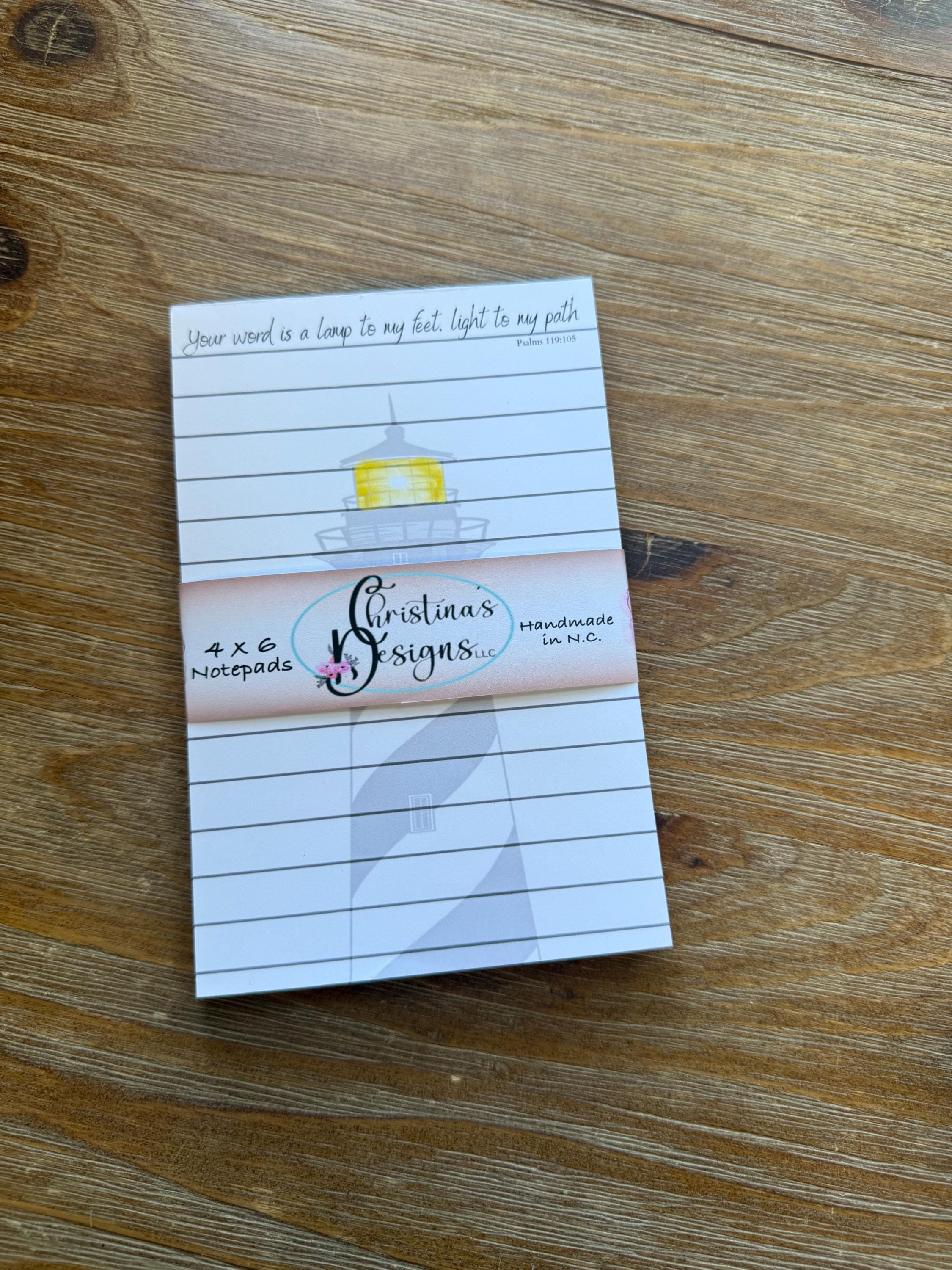 A lined notepad with a decorative border and a small lighthouse illustration on the cover.