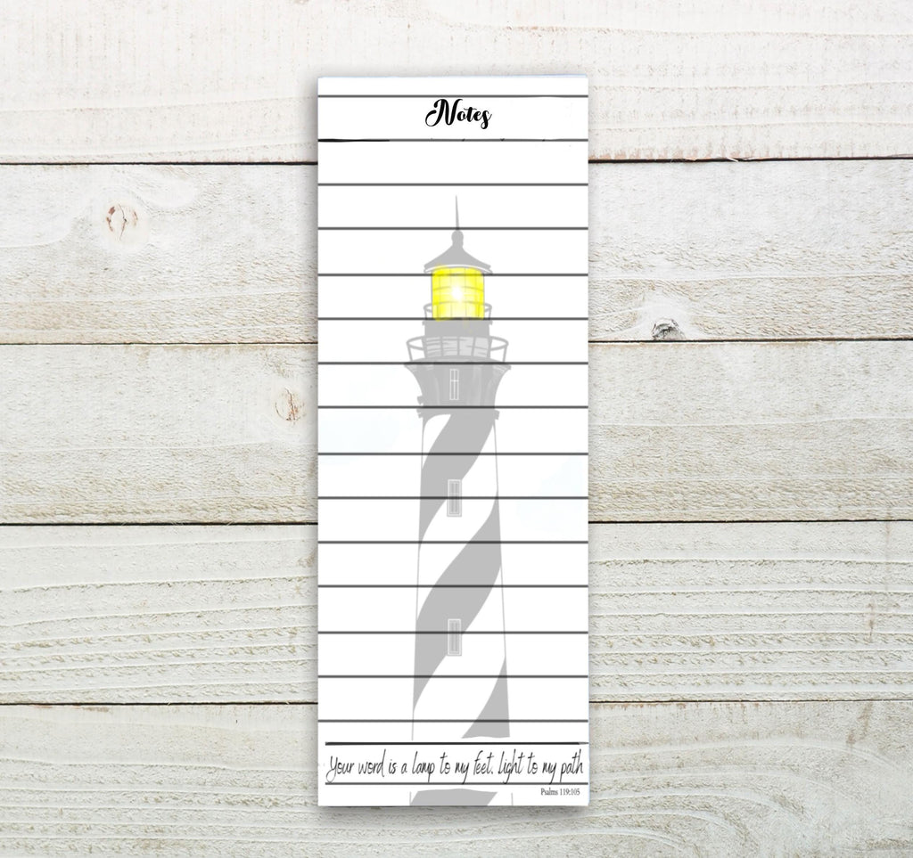 A white vertical notebook with a black and white lighthouse illustration on the cover.