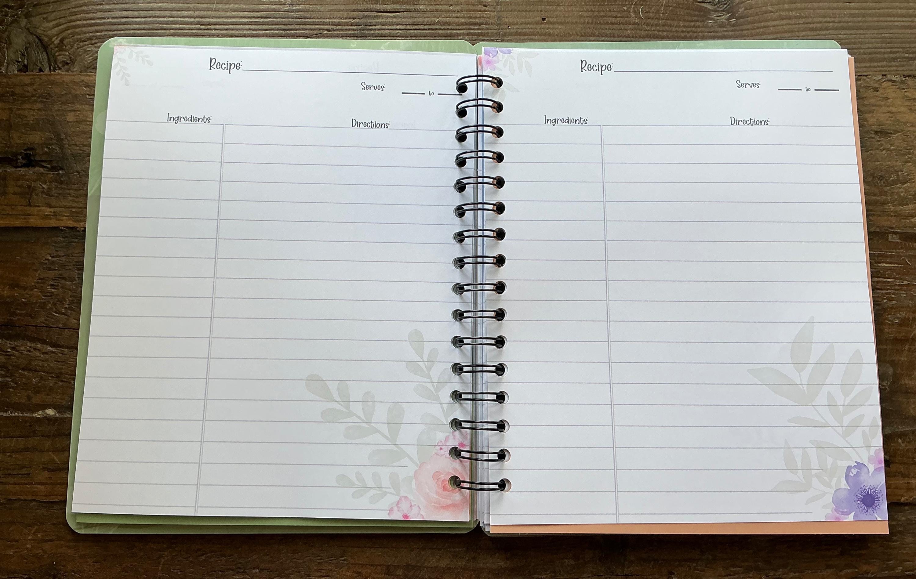 an open spiral-bound recipe book with blank pages, resting on a wooden surface.