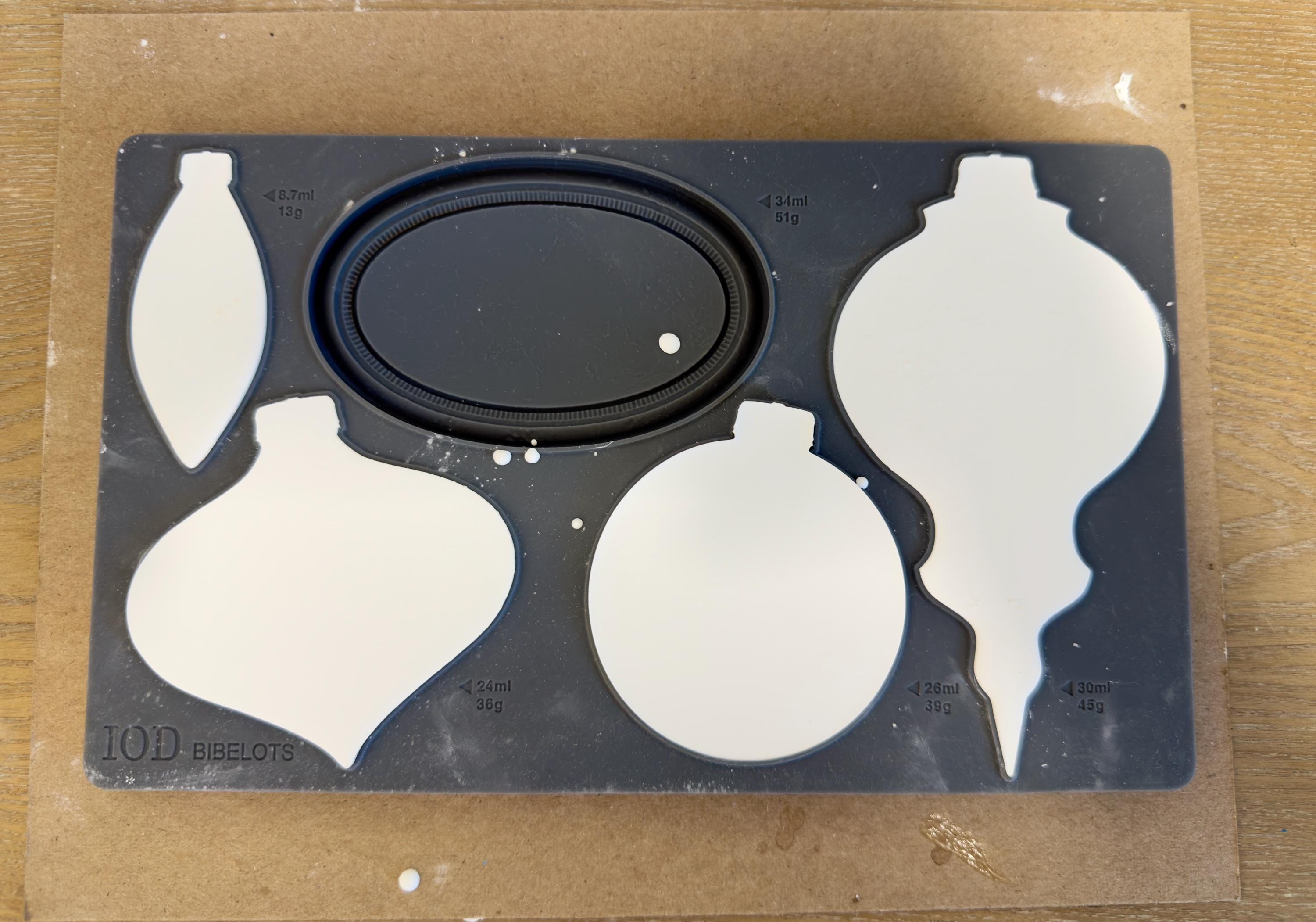 a black tray with white ornaments on it, placed on a wooden surface.