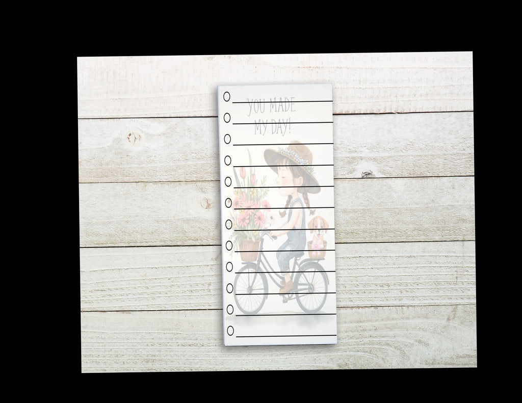 A white piece of paper with a list of items written on it, placed on a wooden surface.