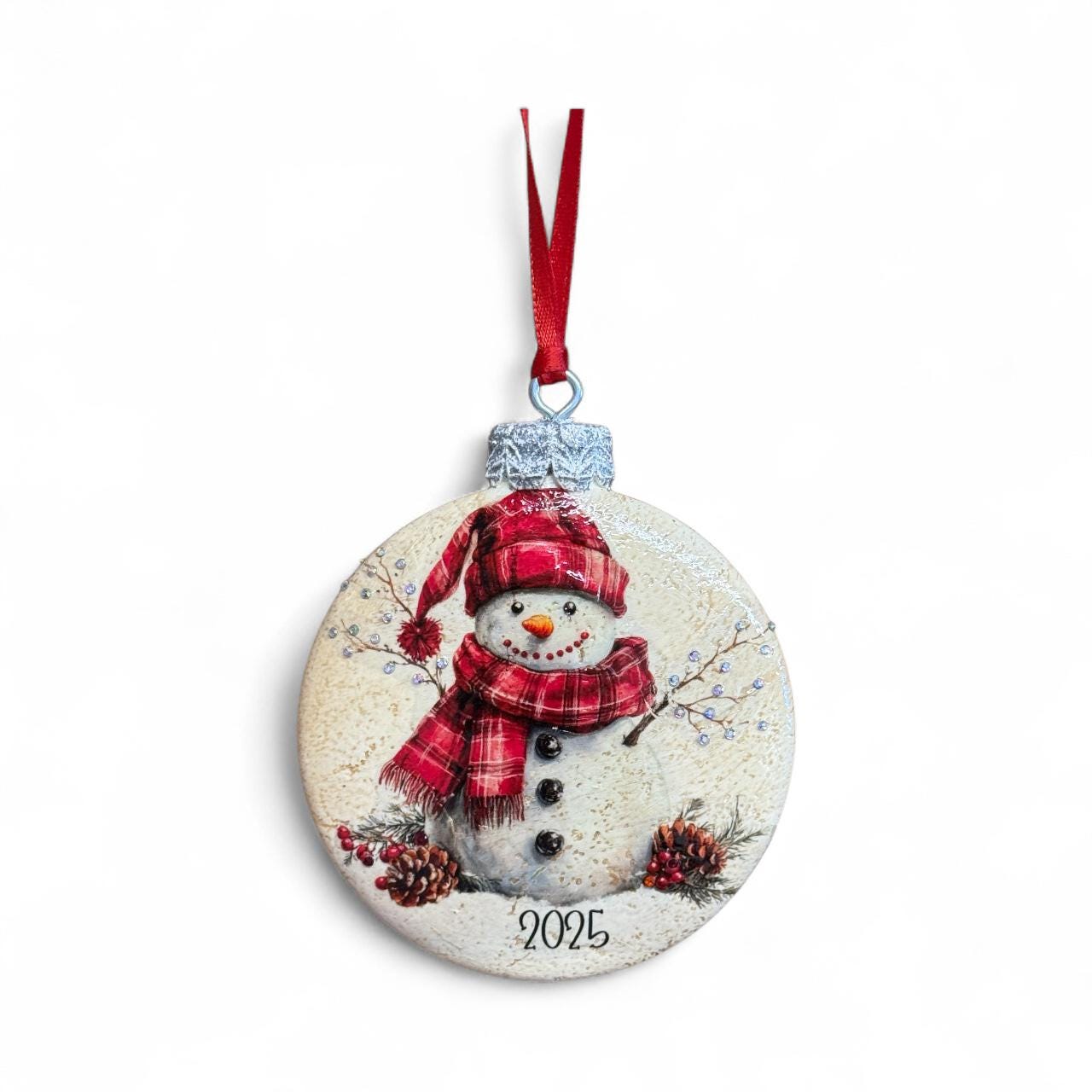 A snowman ornament with a red ribbon and the number "2025" on it, hanging against a white background.