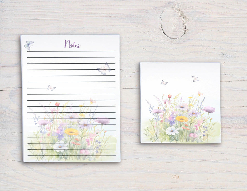 a set of two items placed on a wooden surface. The larger item is a lined notepad with a floral design, and the smaller item is a square-shaped tile with a floral design.