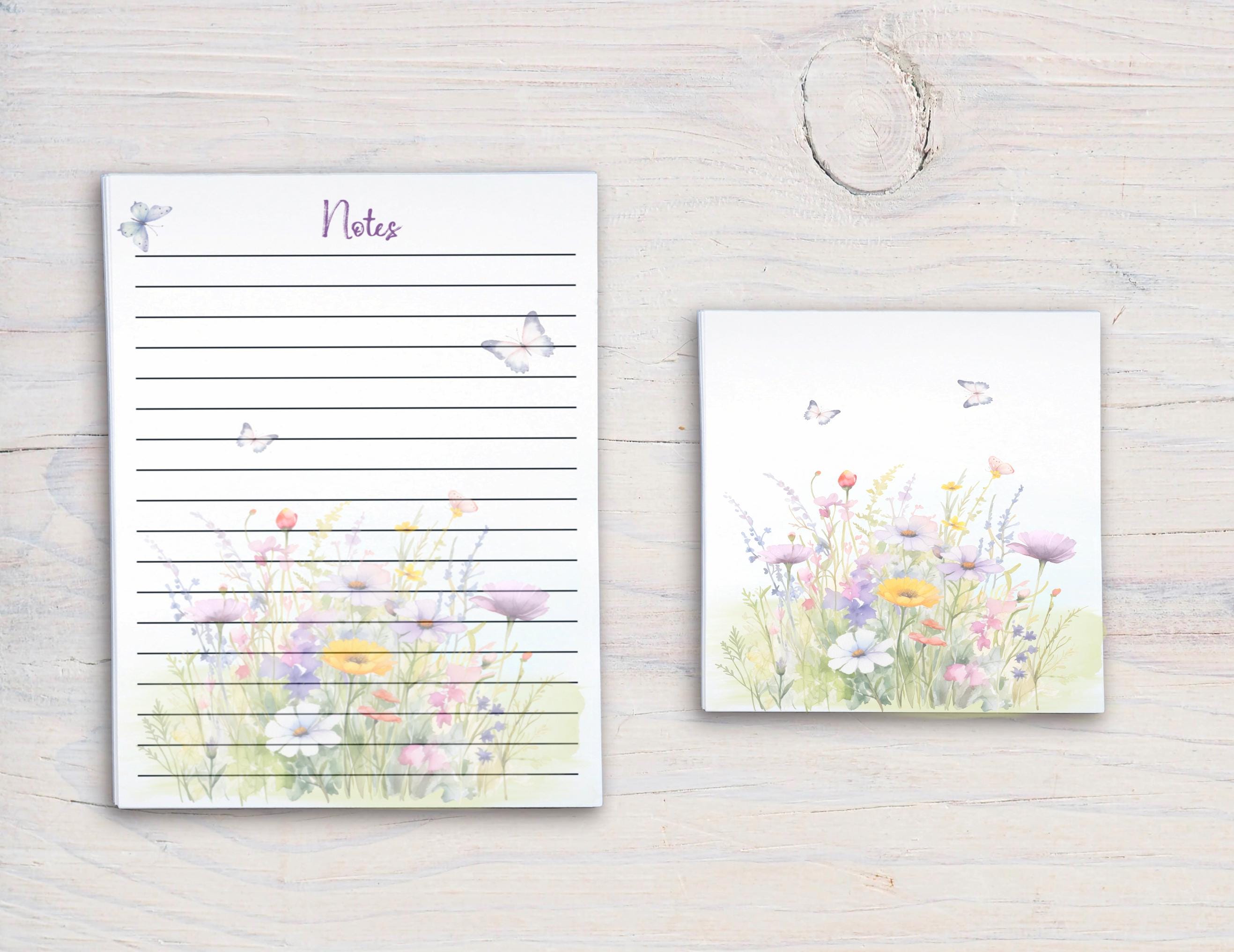 a set of two items placed on a wooden surface. The larger item is a lined notepad with a floral design, and the smaller item is a square-shaped tile with a floral design.