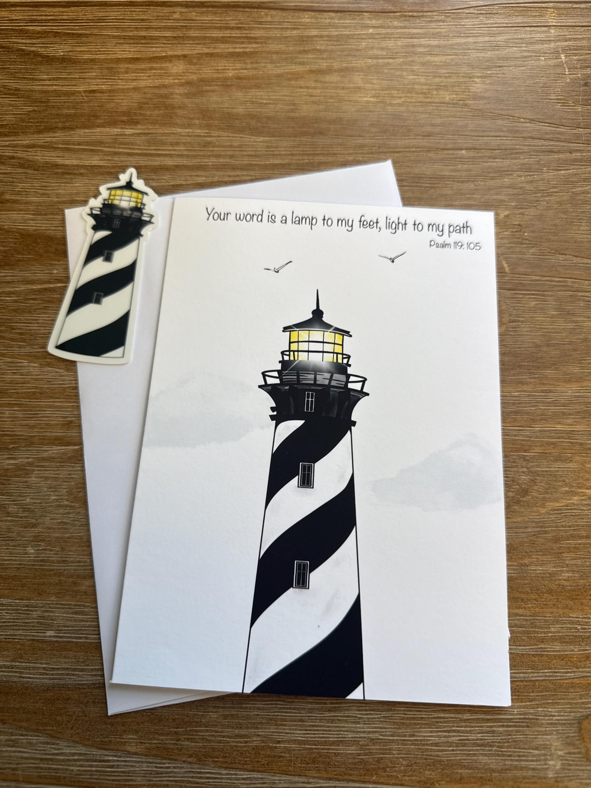 a lighthouse with a black and white striped pattern, and a small sticker of a lighthouse on a wooden surface.