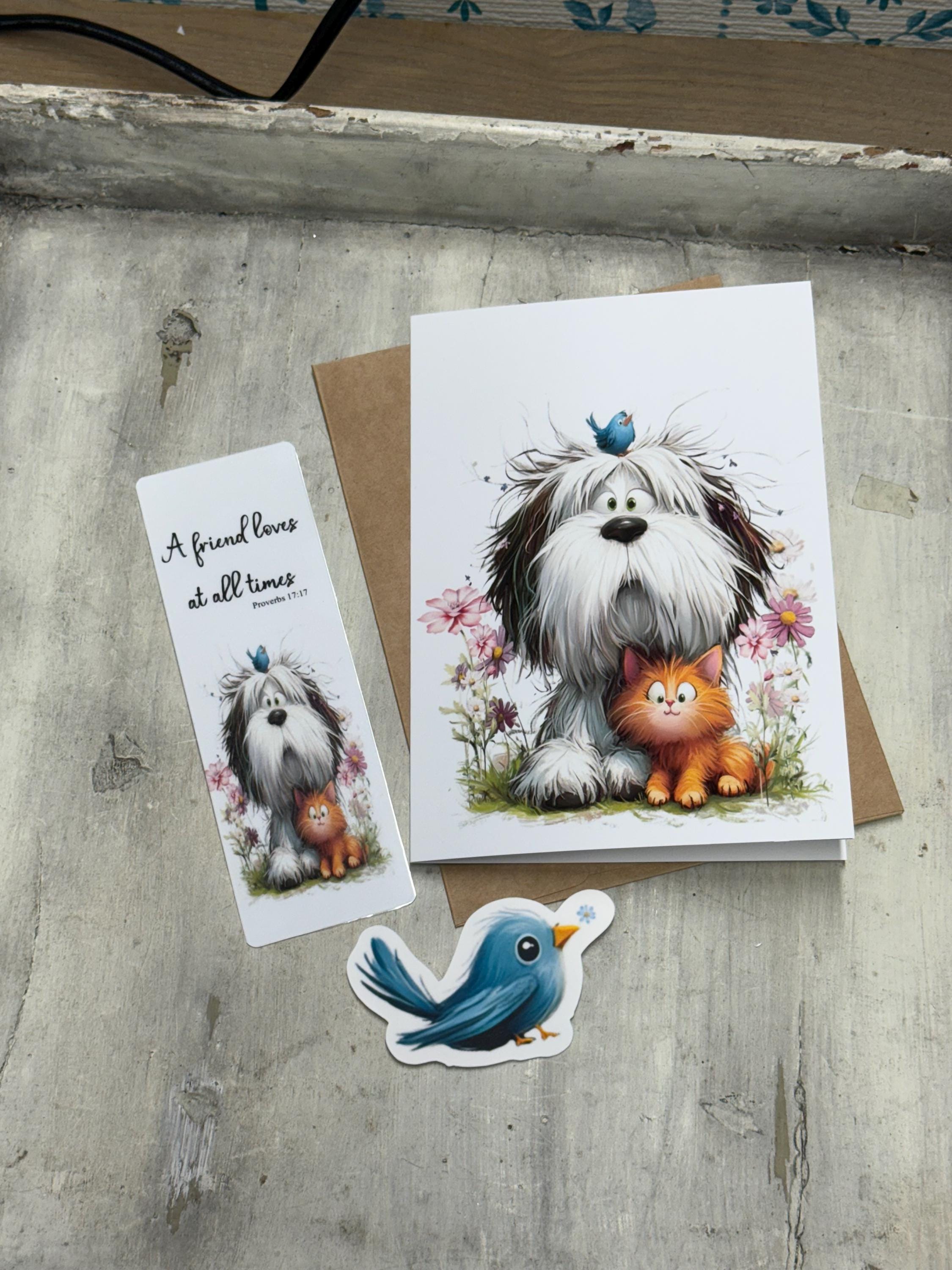 a greeting card with a dog and a cat, along with a small bird-shaped sticker, all placed on a wooden surface.