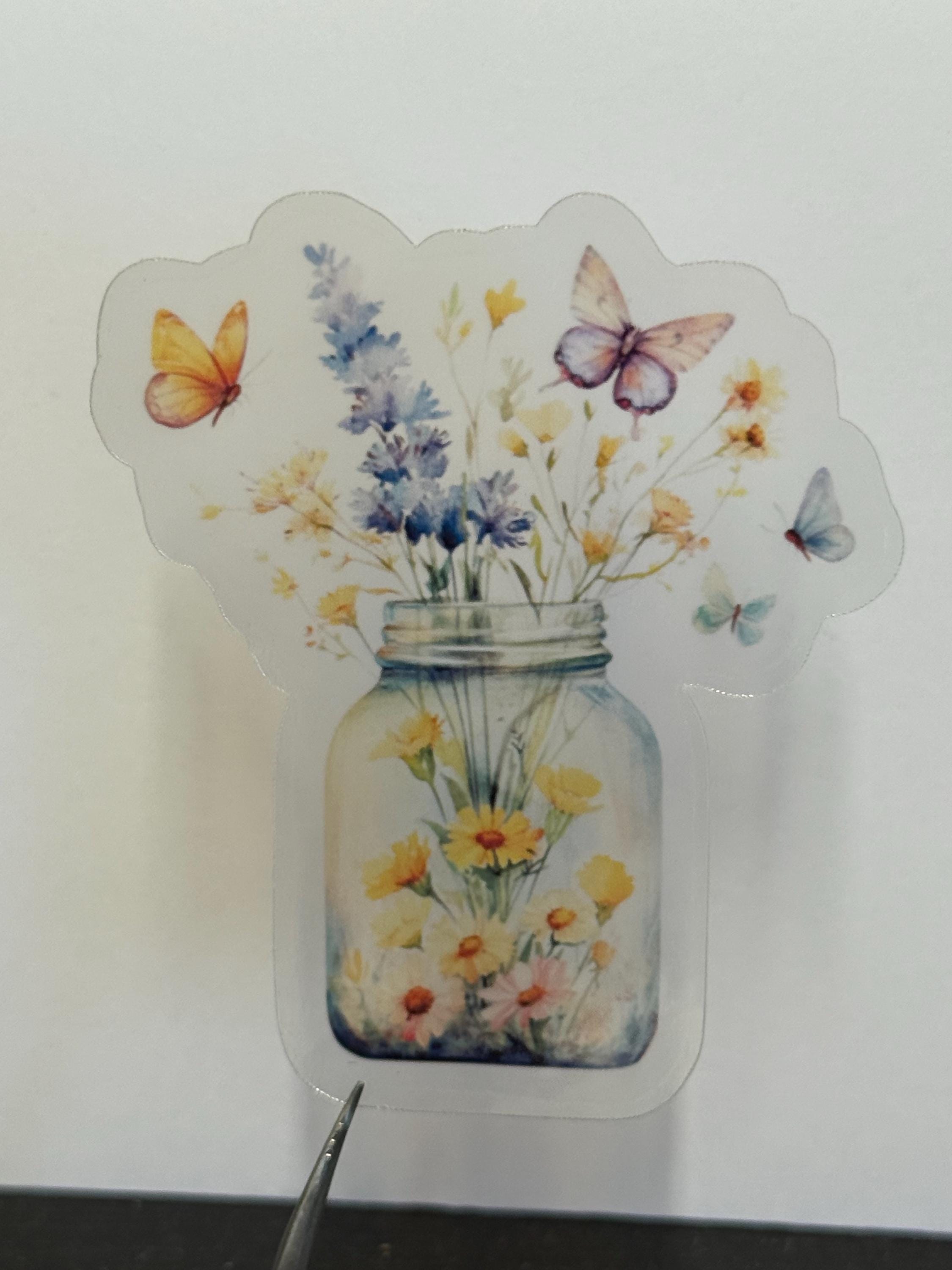 A sticker with a glass jar filled with flowers and butterflies.