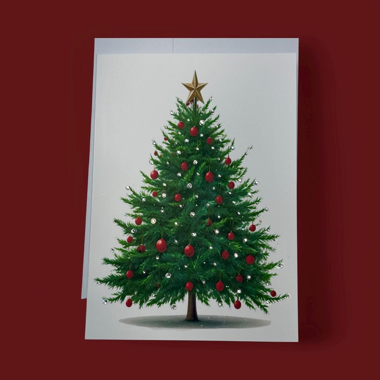 A Christmas tree adorned with red and gold ornaments and a gold star on top, set against a white background.