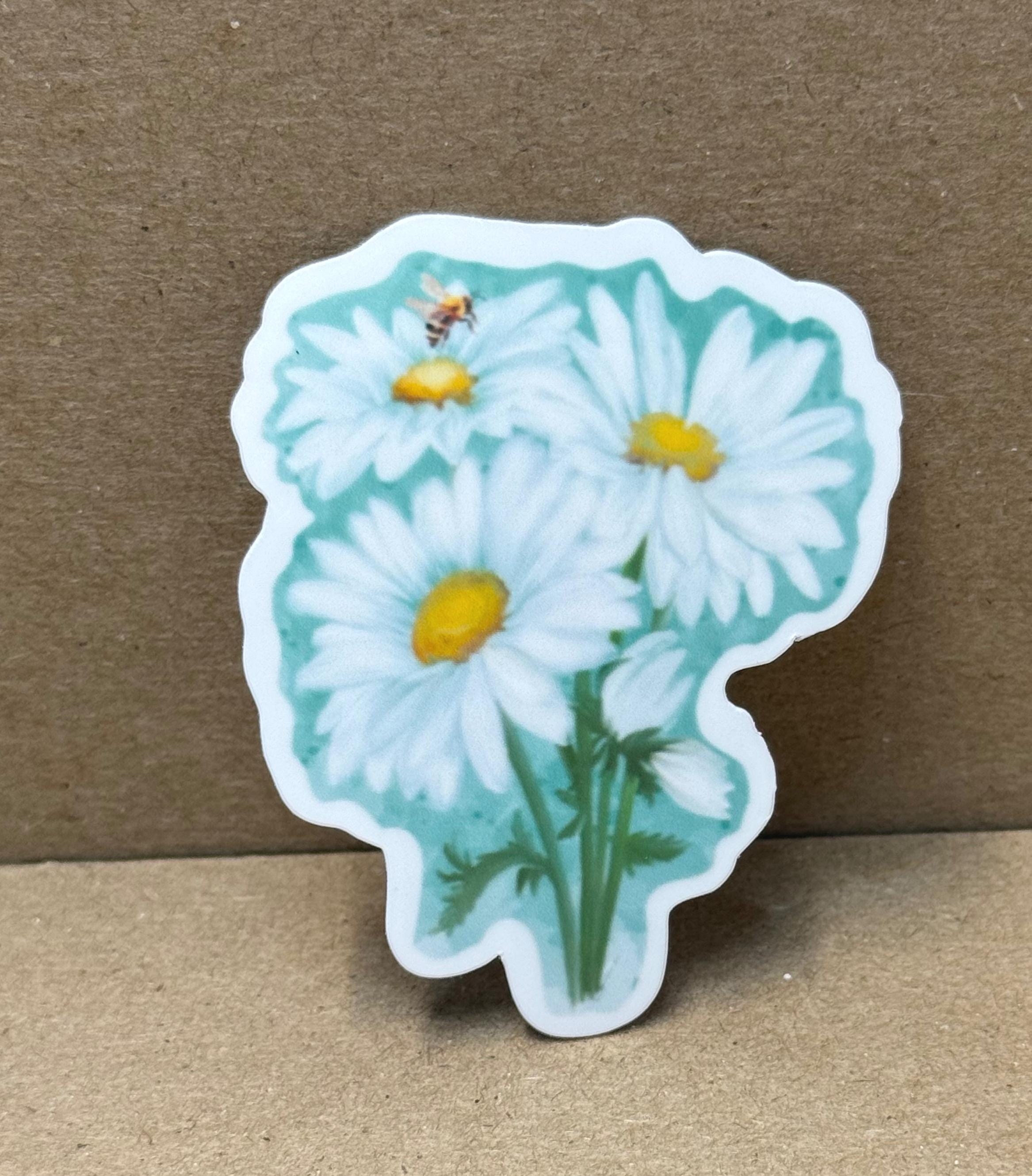 A sticker depicting a bouquet of white daisies with yellow centers, along with a bee on one of the flowers.