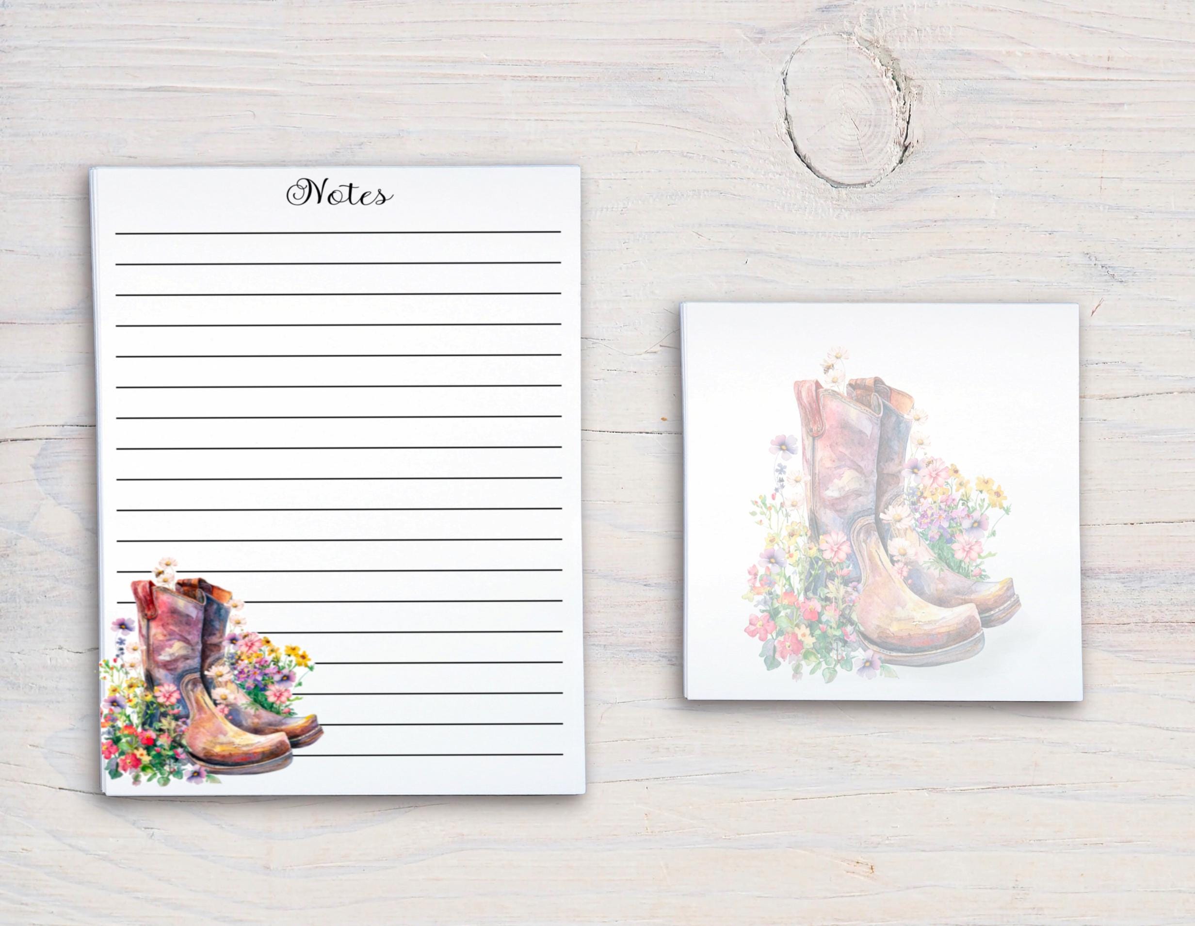 a pair of colorful, patterned boots on a white background, with a blank lined paper pad and a small square tile with a floral design.